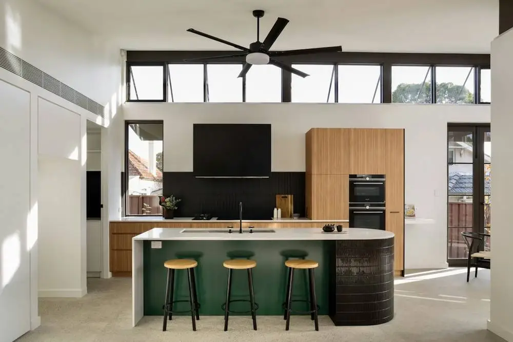 Kitchen with green island and timber cabinets